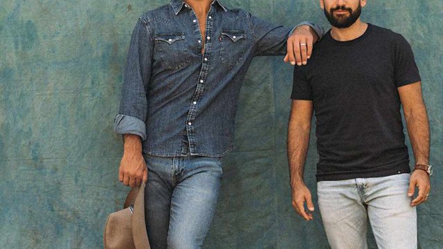 Two country artists posing in front of a painted wall